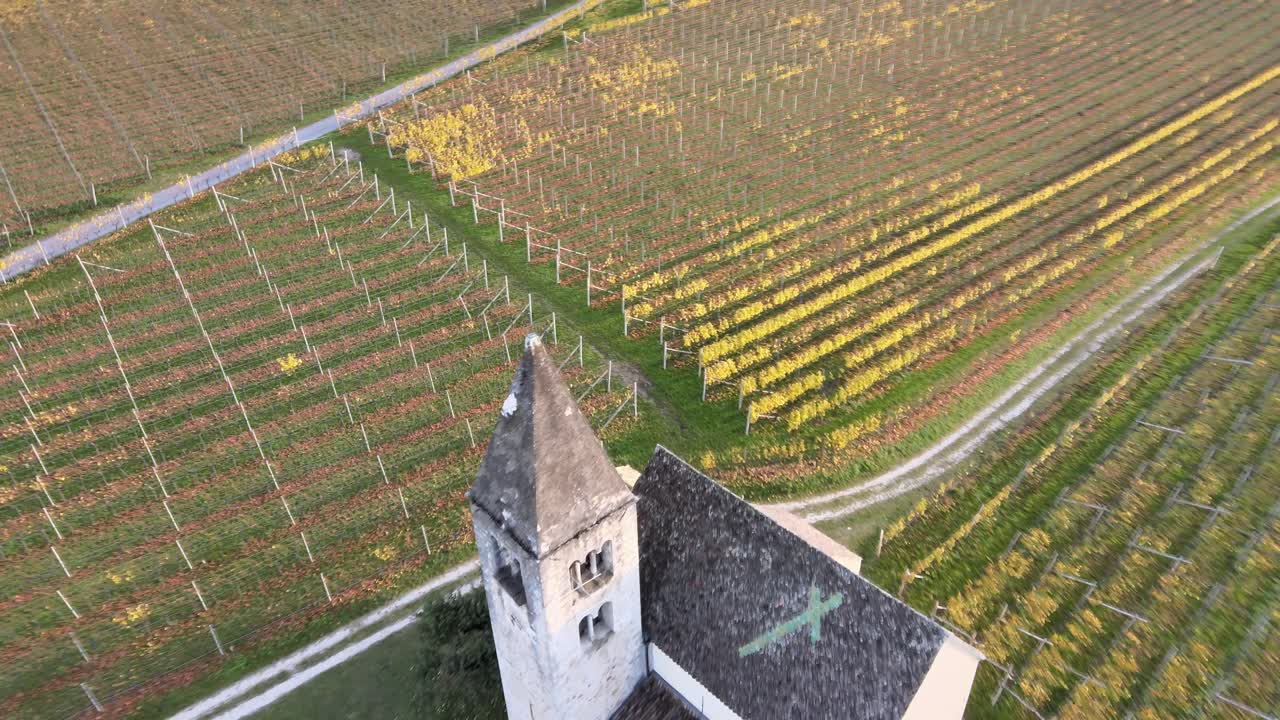 Aerial Drone Over a medieval church in the middle of the Vineyards in Autumn in South Tyrol