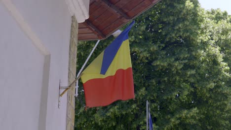 the romanian flag displayed on a church in romania - close up