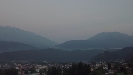 Aerial-view-of-Levico-Terme,-Italy-during-sunrise-with-drone-flying-forward