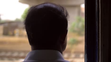 man looking out of train window