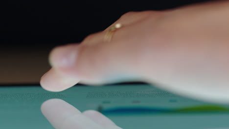 macro de cerca con el dedo utilizando una tableta digital navegación estadísticas de investigación de mercado en línea visualización de documentos de información financiera en un dispositivo móvil con pantalla táctil