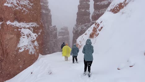 adventurers trekking through snowy canyon with rocky cliffs in bryce canyon usa adventurers trekking through snowy canyon with rocky cliffs in bryce canyon usa