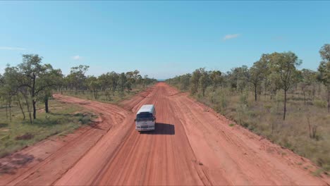 a bus driving down a long flat desert road in the australian outback