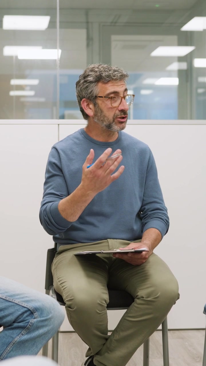 Uomo di mezza età che conduce una discussione in una riunione d'ufficio
