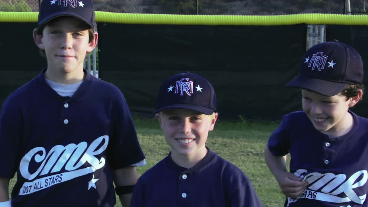 jóvenes jugadores de béisbol cruzan los brazos y posan