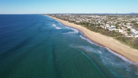 olas salpicando en la playa de arena de la playa de kawana en queensland, australia - toma aérea de un dron