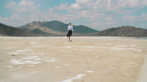 Businesswoman-Tired-And-Wearing-Skirt,-Shirt-Tired-And-Sunglasses-Walking-Alone-In-The-Desert