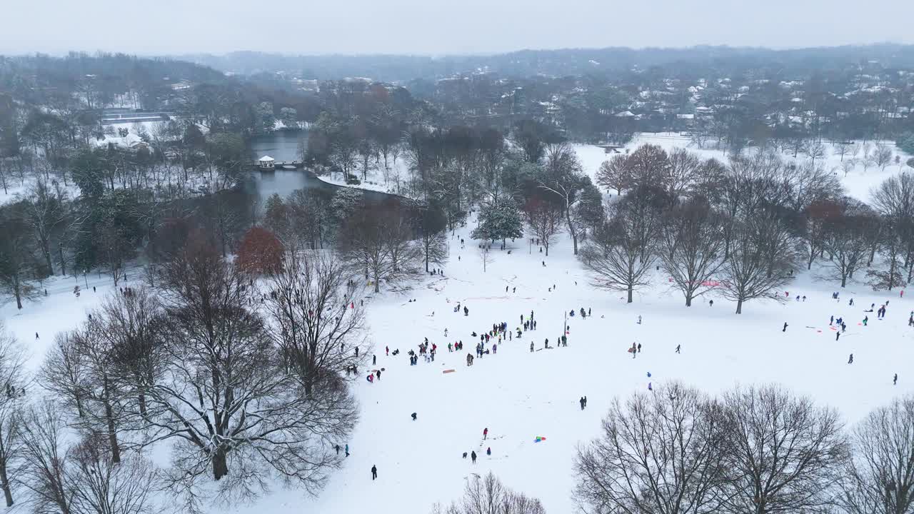 Aerial static shot of people sledding down a hill in Piedmont Park Atlanta, Georgia on January 10th 2025.
