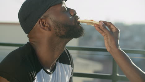 Side-view-of-carefree-gay-eating-Italian-pizza-from-lover's-hands