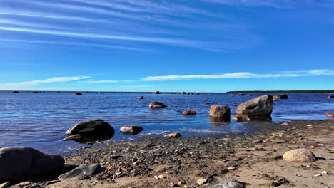 Static-shot-on-a-stony-beach-towards-the-ocean-on-a-sunny-day-in-Estonia,-slowmotion-and-copy-space