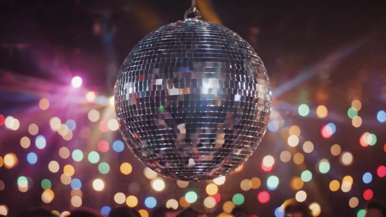 Una vivace notte di ballo: la magia di una palla da discoteca che illumina la pista da ballo con luci colorate e festaioli entusiasti che celebrano insieme