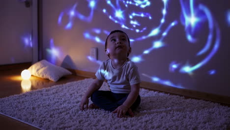 child enchanted by light projector patterns