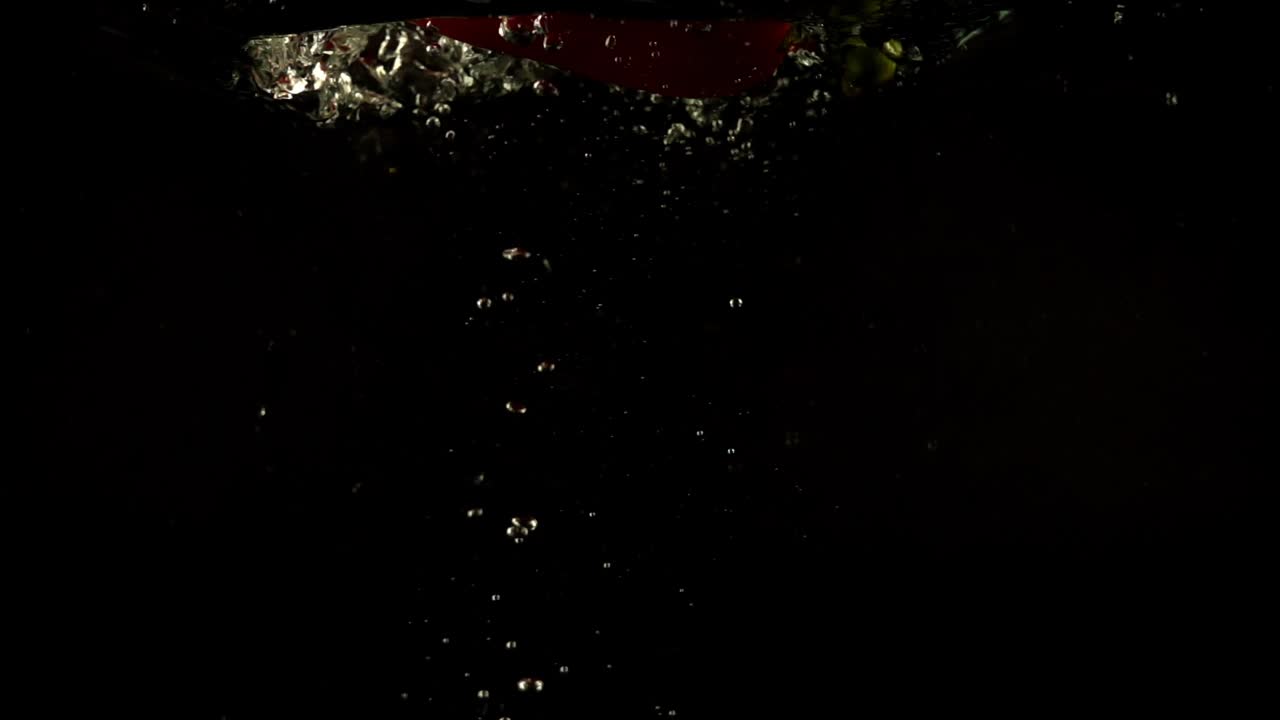 Peperone dolce che cade. Slow motion. Sfondo nero.