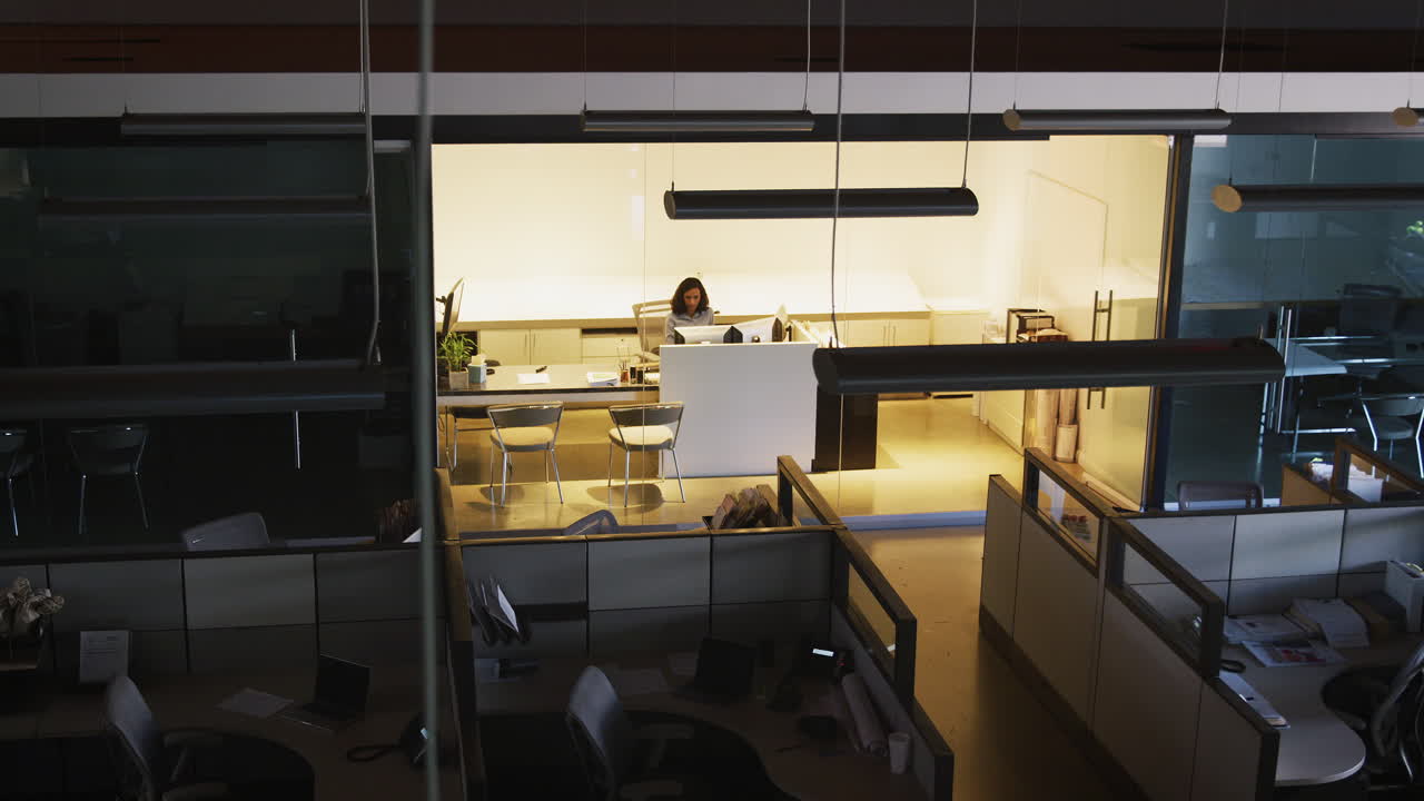 Young businesswoman working in empty office, elevated view