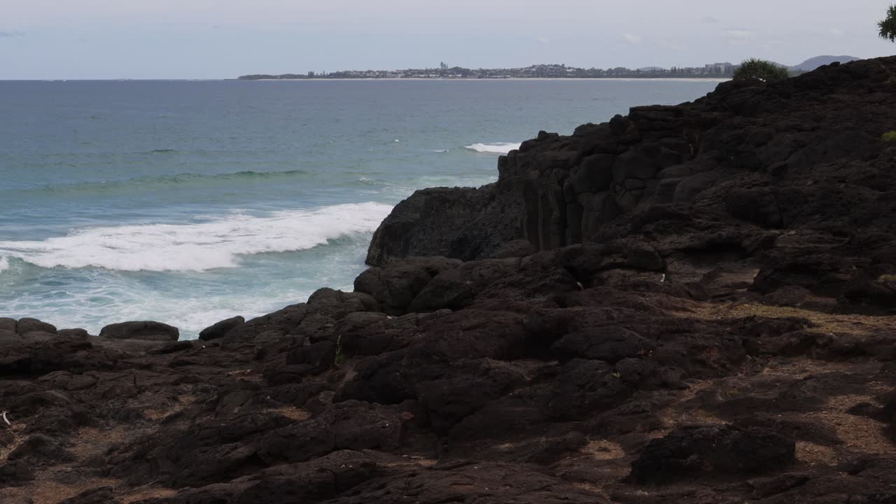 파도가 거친 해안선에 부히고 있습니다.