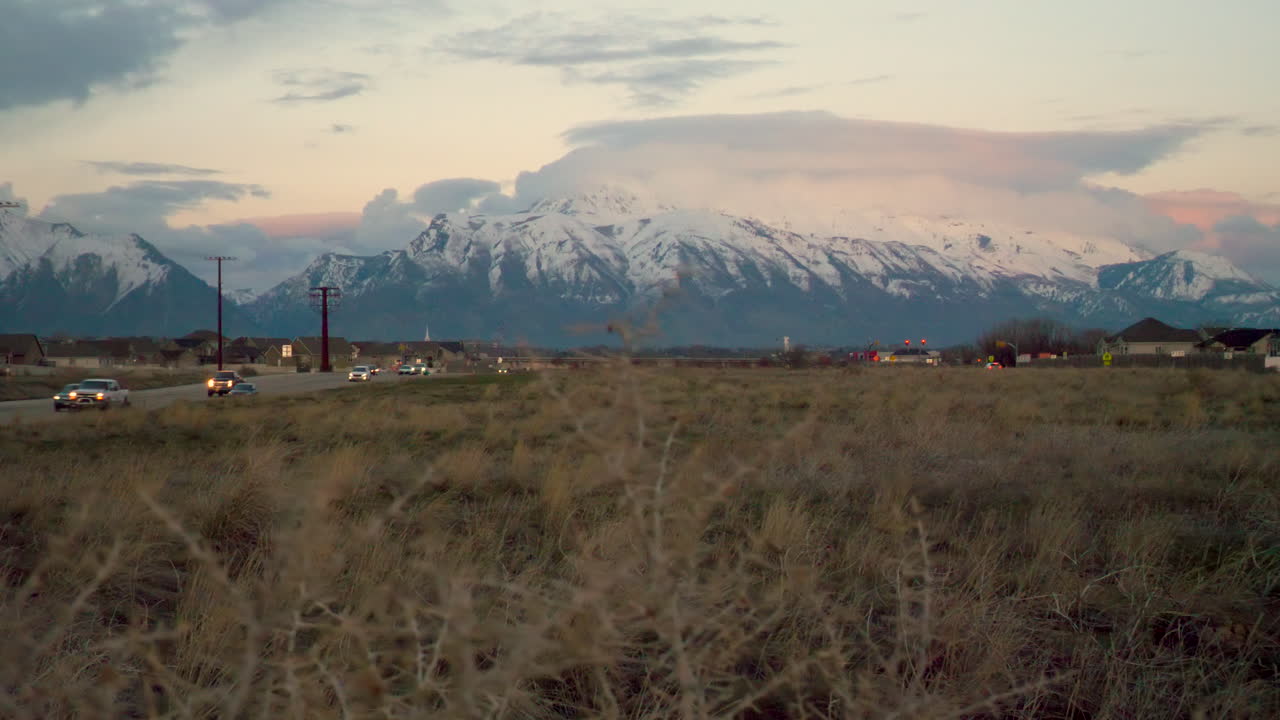 Vista das montanhas nevadas ao amanhecer ou ao entardecer, entre duas estradas rodoviárias - plano deslizante