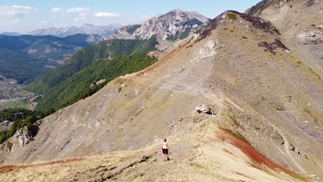 Mujer-Camina-Cuesta-Abajo-Por-Un-Sendero-De-Montaña-En-El-Parque-Nacional-De-Prokletije,-Montenegro---Dolly-Sigue