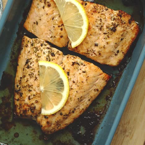 close up shot of healthy grilled salmon served in heat proof ceramic dish  placed on wooden board