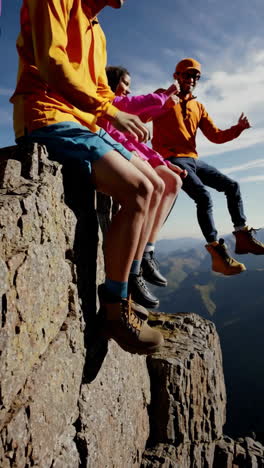 friends enjoying a panoramic mountain view from a cliff edge