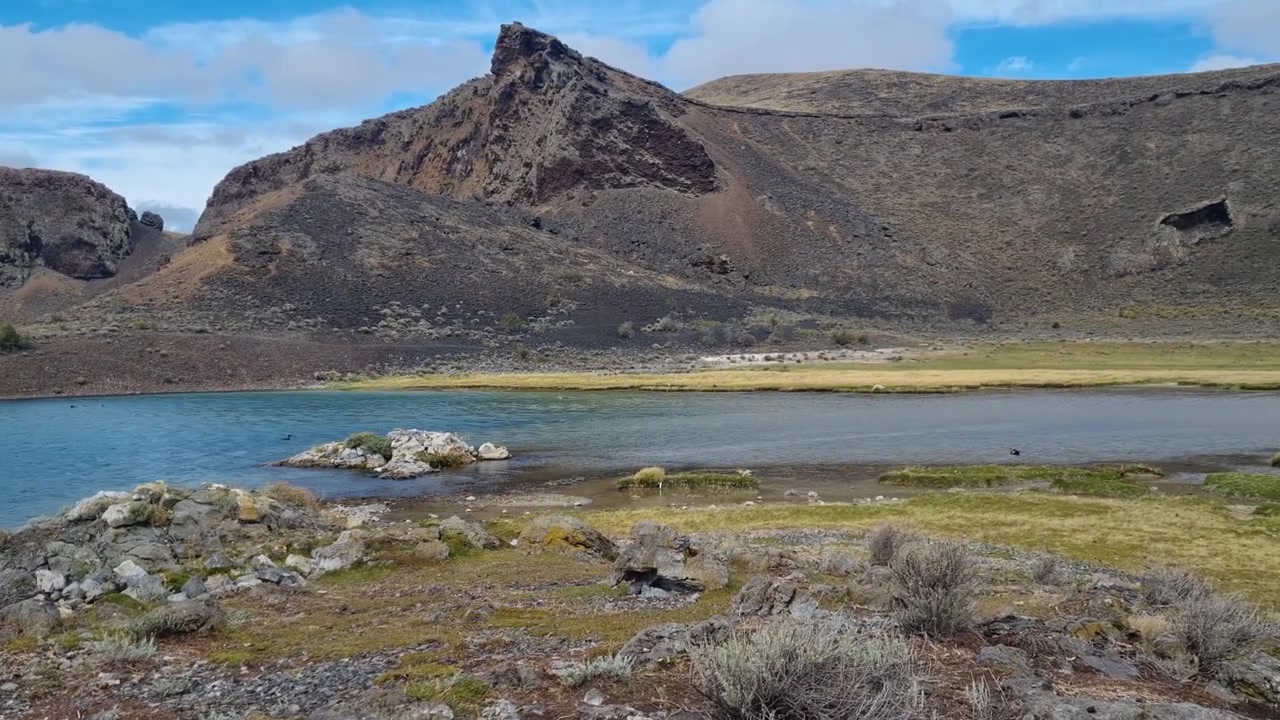 Vista mozzafiato della vulcanica Laguna Azul in un remoto parco nazionale vicino a Río Gallegos, Argentina. La natura selvaggia della Patagonia e la bellezza aspra creano un'atmosfera serena e incontaminata nel campo vulcanico di Pali Aike