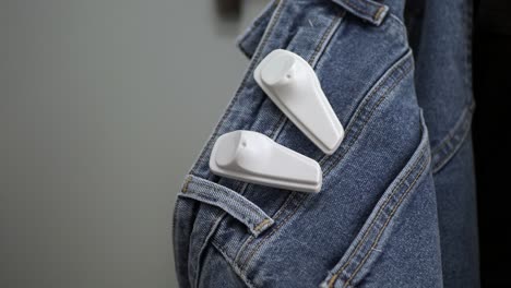 close-up of two security tags attached to a pair of blue jeans