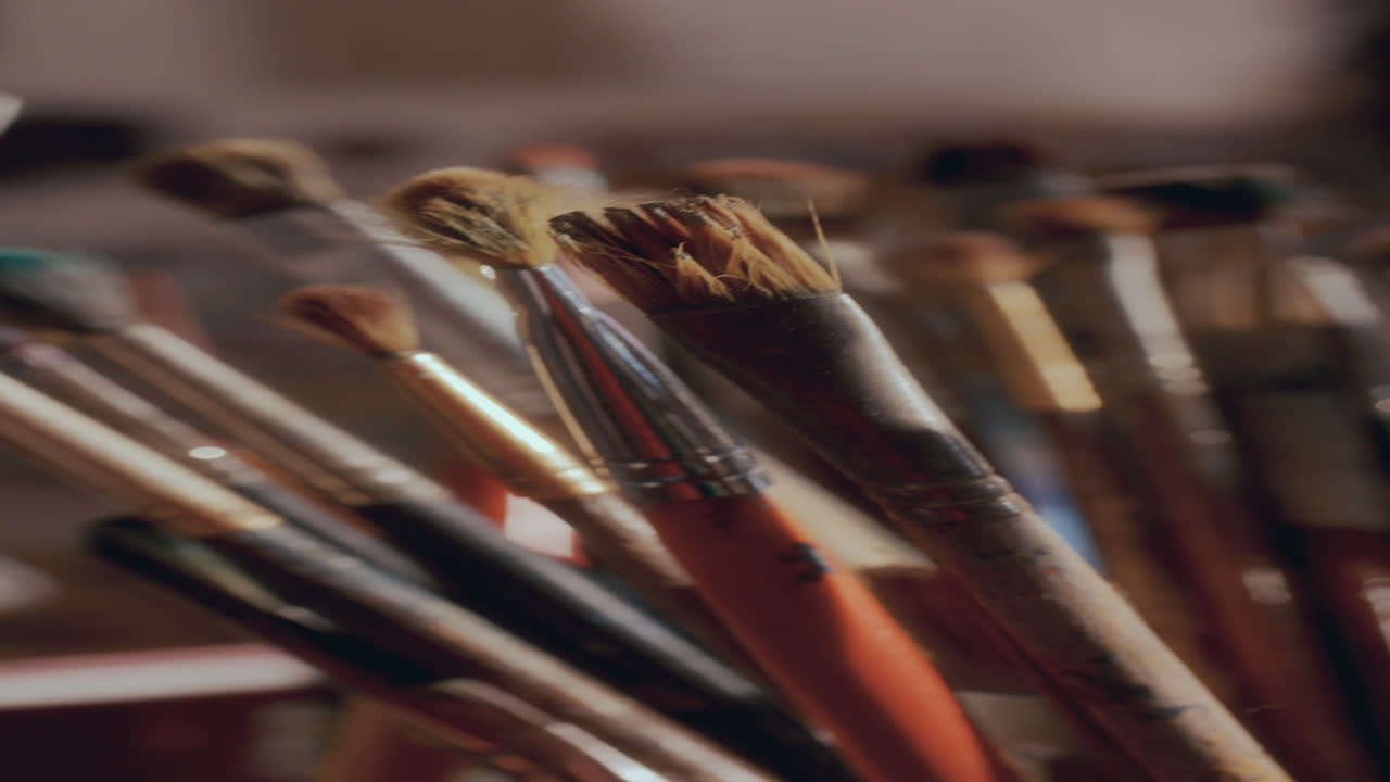 Primo piano di una varietà di pennelli usati in uno studio d'arte.