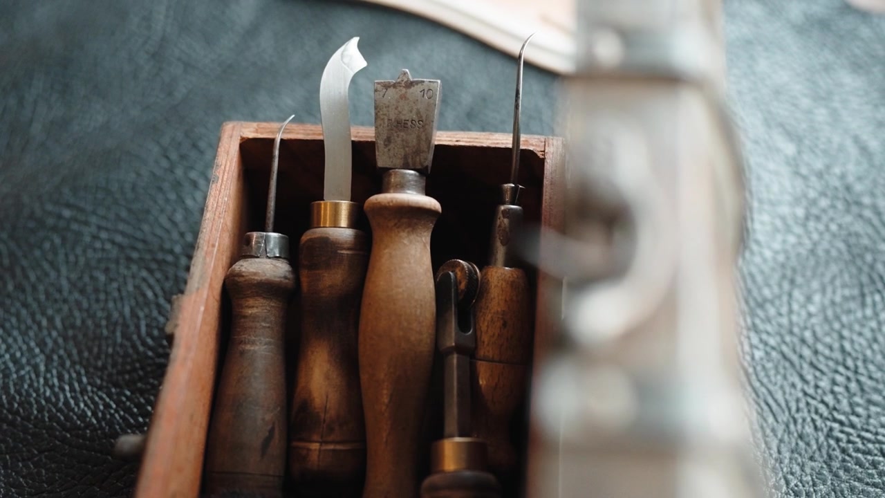 Cobbler Awls and Curved Knife with Worn Wooden Handles Standing in Box on Leather