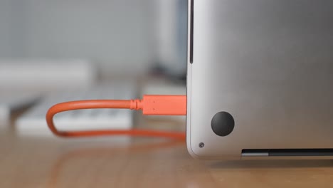 hand plugging usb cord into usb port in computer