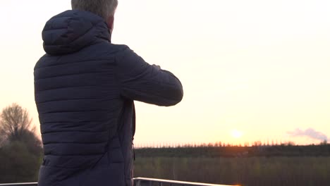 a person is taking photos with his phone while standing on a viewing platform