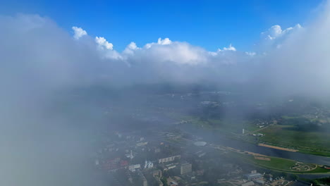 aerial view of jelgava city partially covered by clouds with lielupe river in the distance
