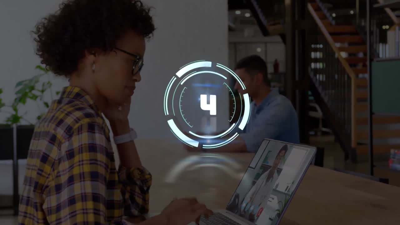 Animation of countdown over african american businesswoman having laptop video call with doctor