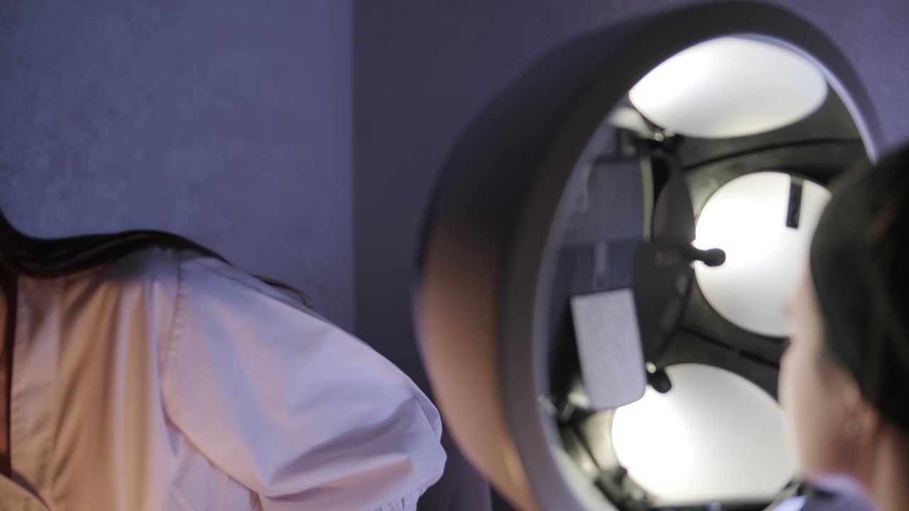 램프 아래에서 얼굴 검사를 수행하는 미용학자