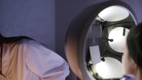 cosmetólogo realizando un examen facial bajo una lámpara