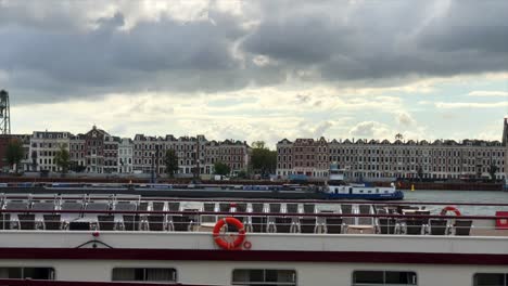 cargo ship sailing through port with dutch houses in background