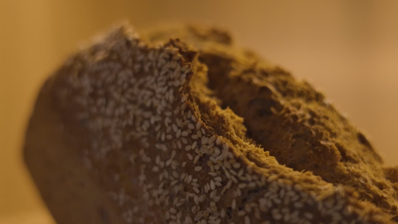 Crispy crust of freshly baked bread with flour and sesame seeds, copy space, macro shot