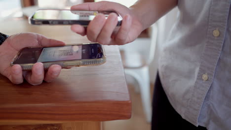 Friends-using-smartphone-for-payment-at-cafe-restaurant-for-split-payment