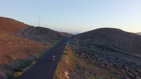 Aerial-shot-of-a-young-athletic-woman-cycling-on-a-road-bike-in-the-mountains-in-Spain