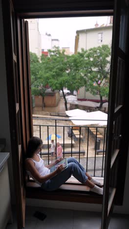 woman working from a balcony in a city