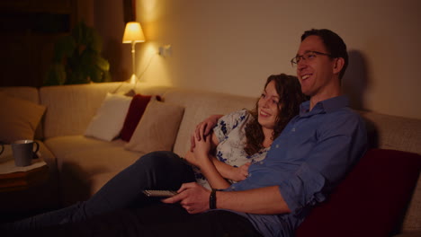 Young-Couple-Watching-Tv-At-Home-Siting-On-Softa-In-Living-Room-4