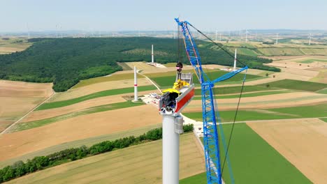 huge crane in wind turbine head construction - drone shot