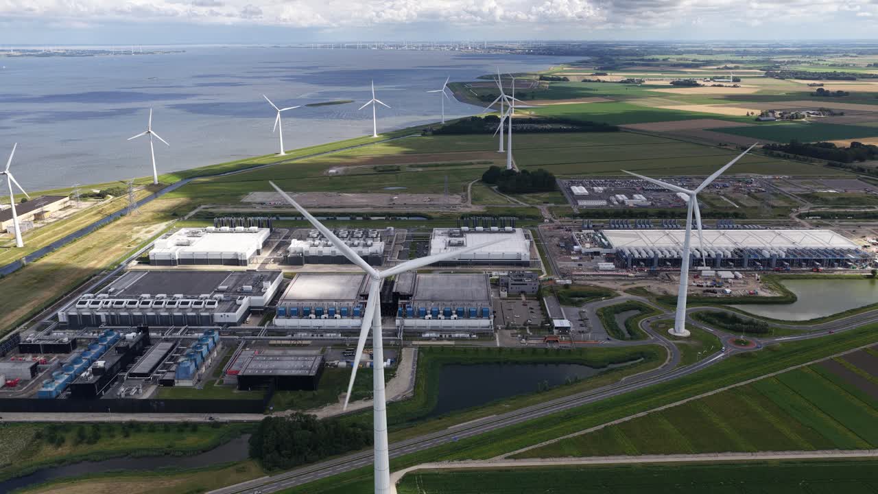 Wind turbines at a data center in Eemshaven, Groningen, The Netherlands. AI, cloud, server infrastructure, and renewable energy. Aerial view