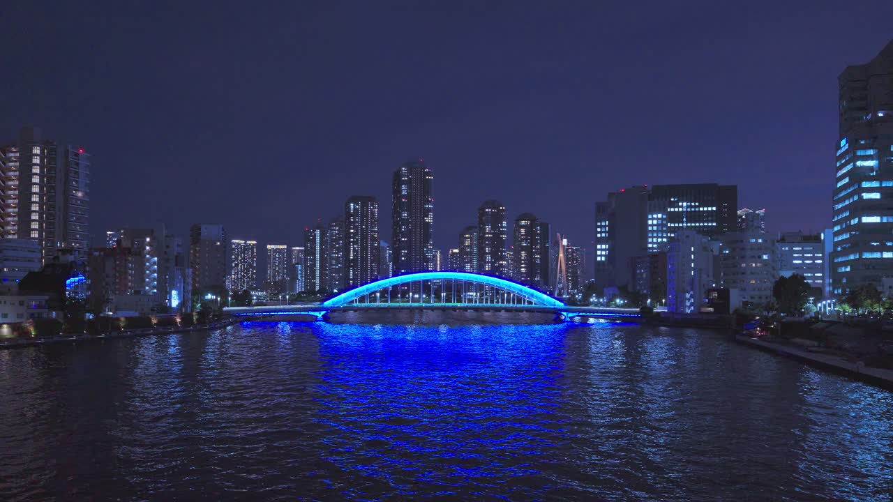 Night cityscape with a bridge illuminated in blue
