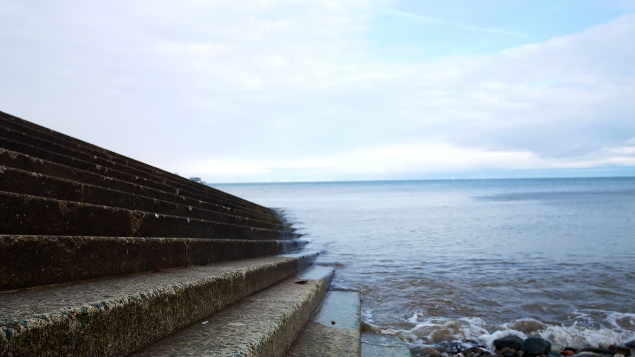 오른쪽 샷으로 내려가는 바닷물로 이어지는 콘크리트 보트 착륙 단계에 대한 파도 세척
