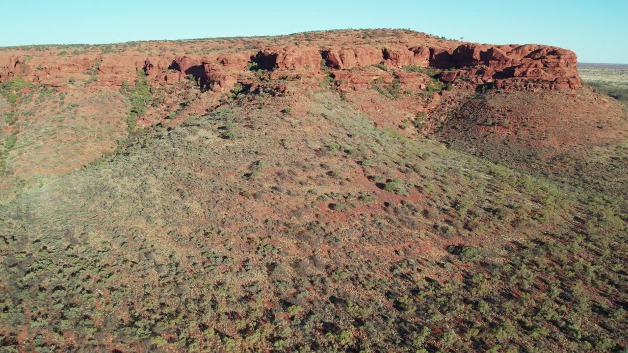 Aerial footage heading of a mountain ridge near Kings Canyon, Watarrka, in the Northern Territory, Australia. August 2022.