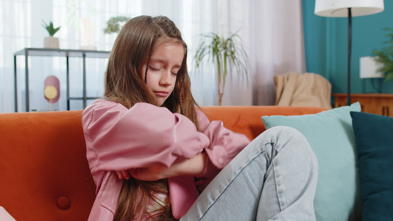 Upset child girl using smartphone playing game loses loss fail education study test at home couch