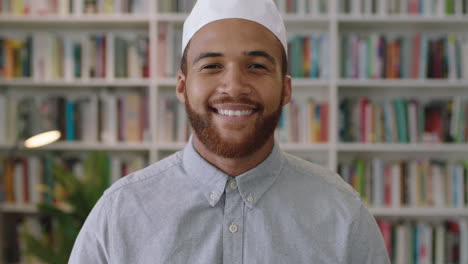 young confident middle eastern man standing in library looking smiling portrait of proud entrepreneur