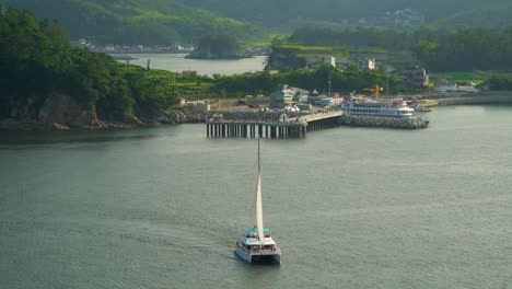 aerial view of catamaran boat with vacationist cruising near hanwha resort in geojedo island, south korea