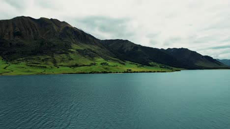 Paisaje-De-Nueva-Zelanda-Vista-Aérea-De-Drones-De-Exuberantes-Montañas-Verdes-En-El-Lago