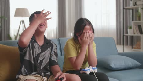 asian children with joystick game playing video games and disappointed