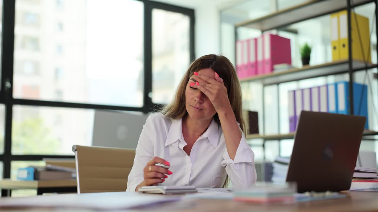 Businesswoman working and experiencing stress in an office